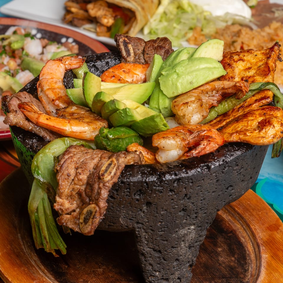 Magueys Mexican Restaurant's molcajete with grilled shrimp, steak, chicken, avocado, and green onions.
