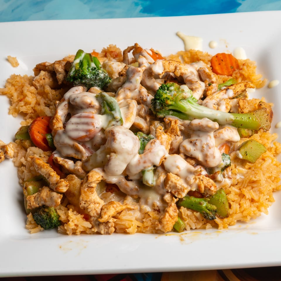 Magueys Mexican Restaurant's creamy chicken and vegetable dish with rice on a white plate.